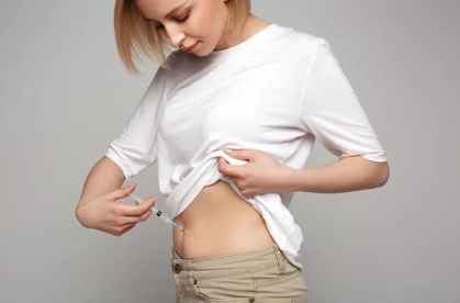 Person selecting and marking a safe B12 injection site on the outer thigh at home