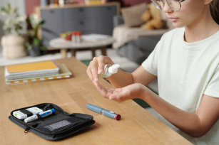 Person opening a B12 injection kit at home while following online self injection instructions